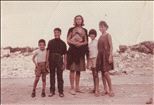 Neighborhood kids taking a photo with a tourists visiting Musrara